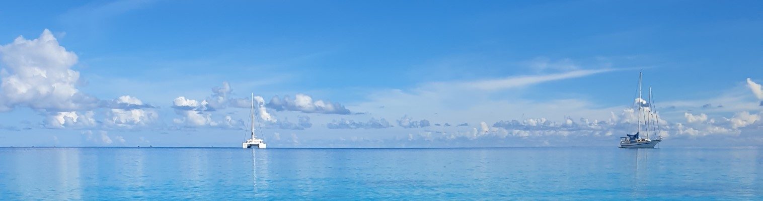 Blick über das offene Meer mit zwei Yachten am Horizont
